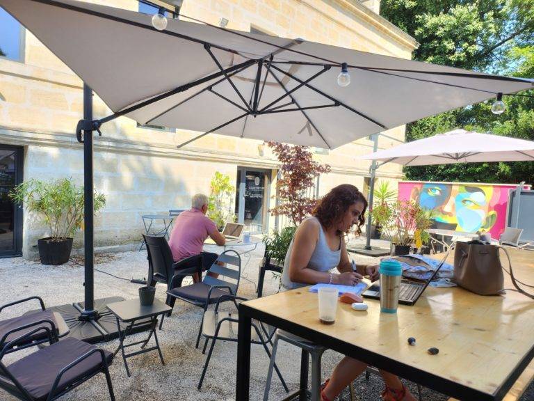 Café ou travail en terrasse sous l'œil de la fresque d'Alber